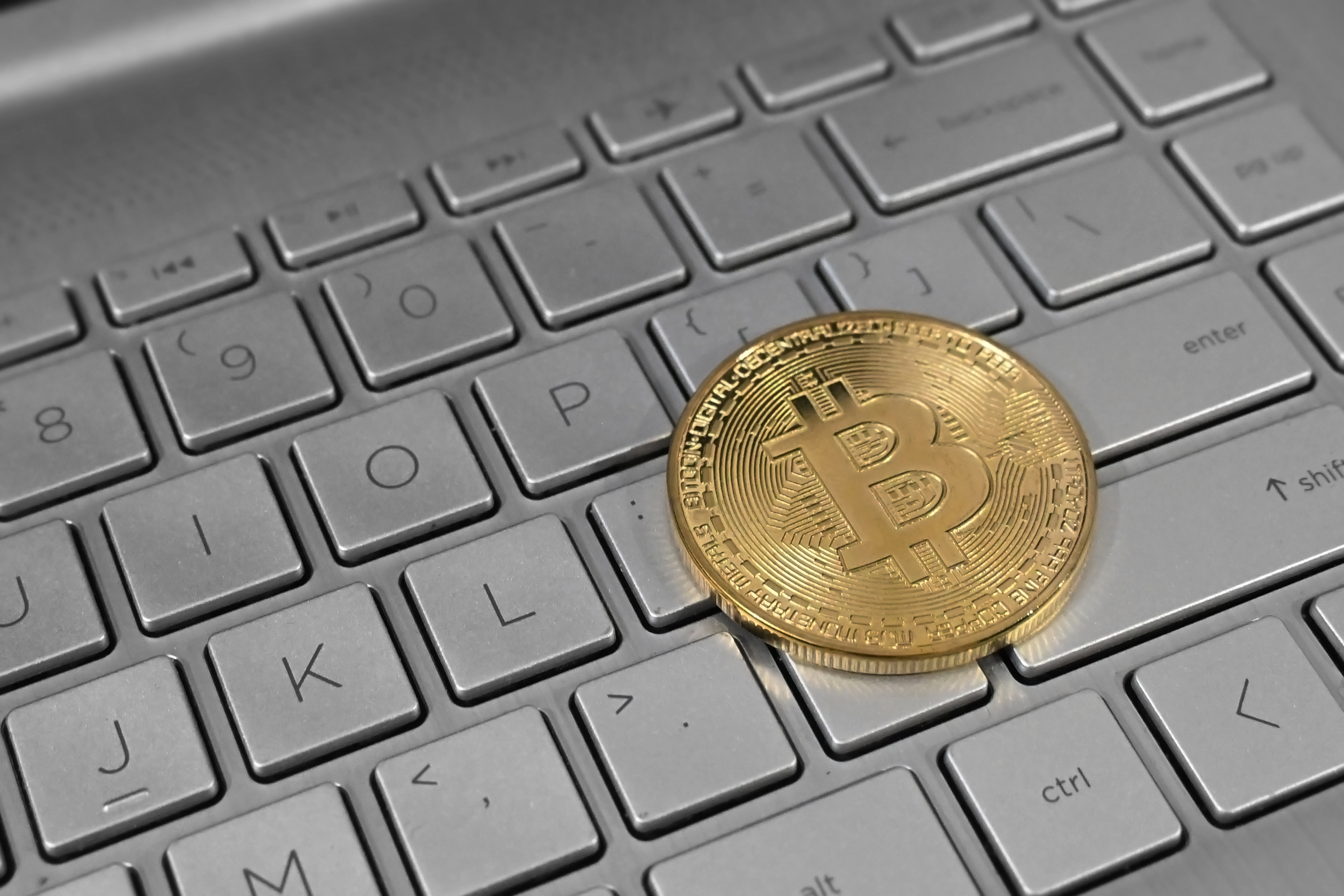 Pièce Bitcoin physique sur clavier d'ordinateur